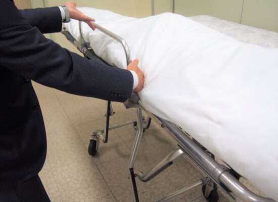 Undertaker loading a body onto a stretcher