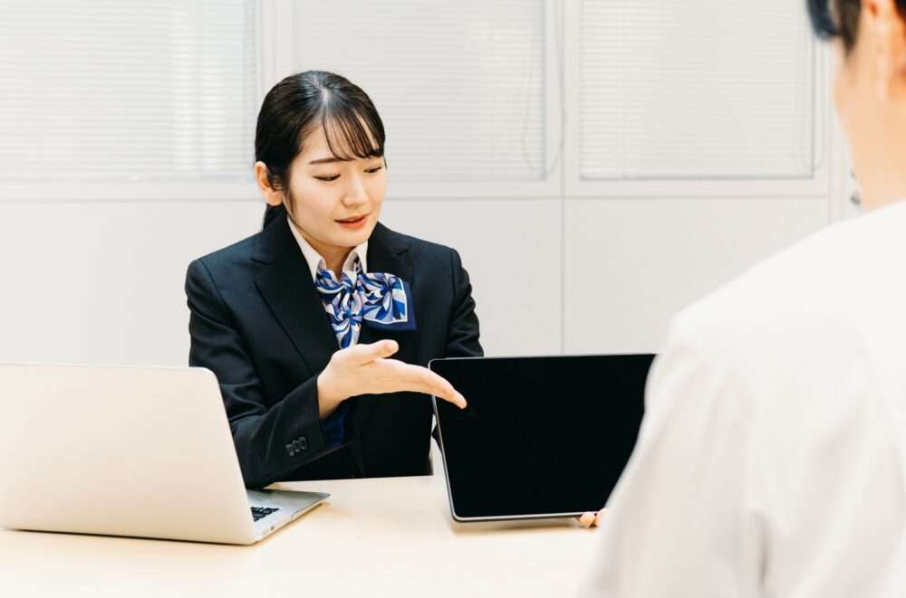 Female funeral director explaining funeral plans to client on laptop