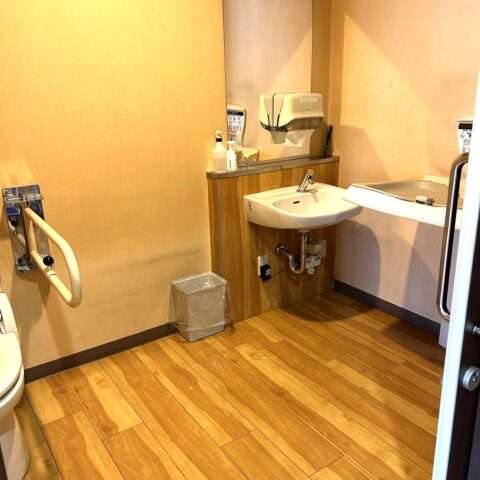 A spacious restroom with a diaper changing station for the disabled.