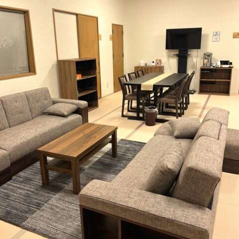 A waiting room for bereaved families equipped with a six-seater dining table and two sofa beds