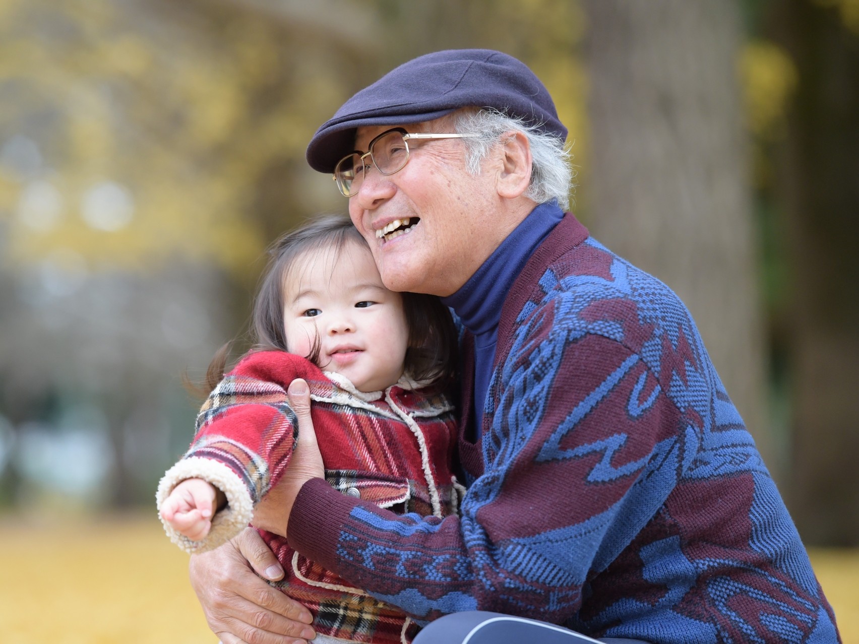 Smiling grandfather holding his granddaughter